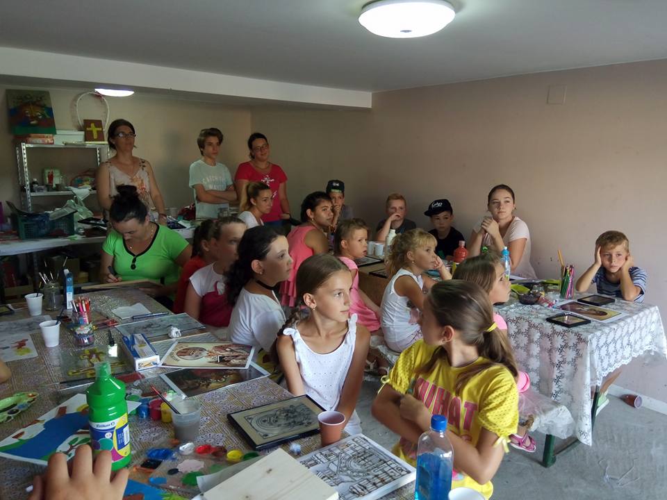 FOTO. Un preot a organizat o școală de vară pentru zeci de copii. Asistență medicală, pictură pe sticlă și excursii