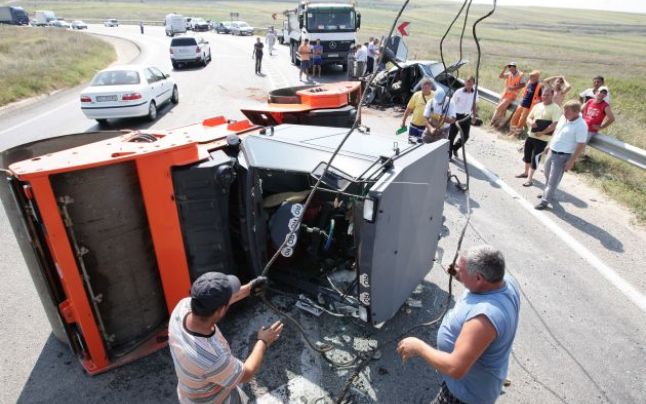 Muncitorul unei firme de asfaltări a distrus cu compactorul o mașină. Nu avea permis de conducere!