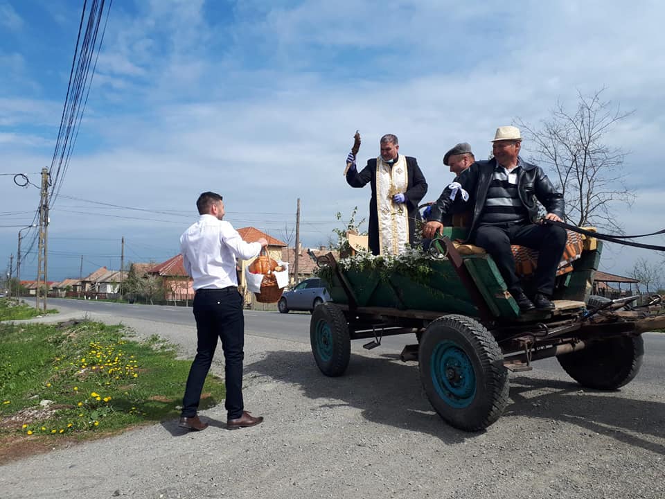 FOTOGALERIE. Preot greco-catolic sfințește coșurile dintr-o căruță împodobită cu flori
