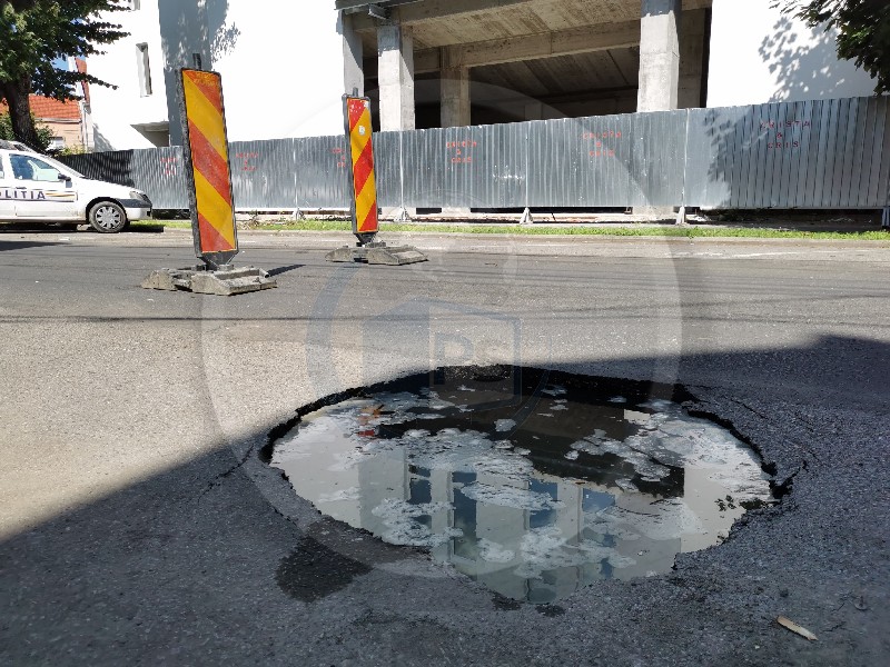 FOTOGALERIE. S-a surpat o bucată din șosea în centrul Sătmarului. O femeie a ajuns cu roata în groapă