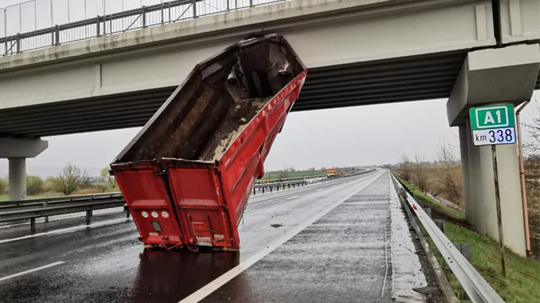 FOTOGALERIE. Accident bizar. I-a explodat roata, iar remorca camionului a rămas agățată de un pod