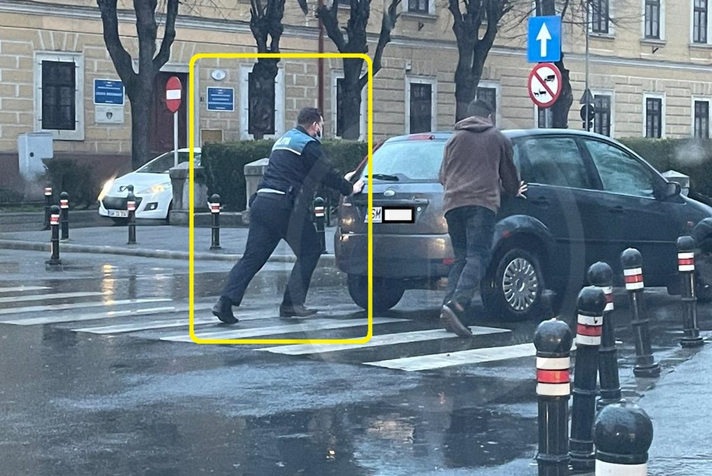 FOTO. Polițistul zilei în Satu Mare. Pe ploaie, a sărit să ajute un șofer cu mașina defectă