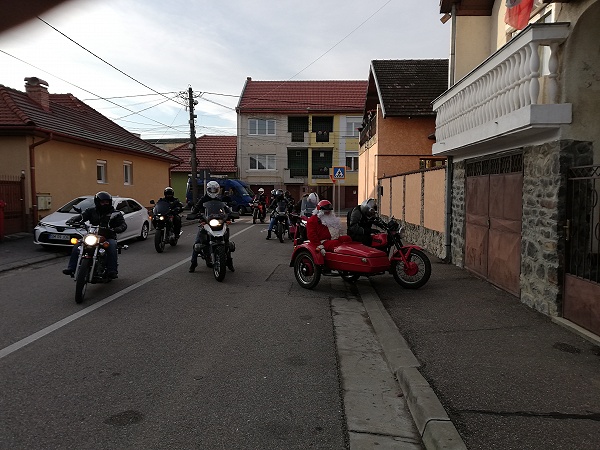 FOTO. A lăsat sania și s-a urcat pe motocicletă. Moș Crăciun le-a făcut o surpriză orfanilor din Satu Mare