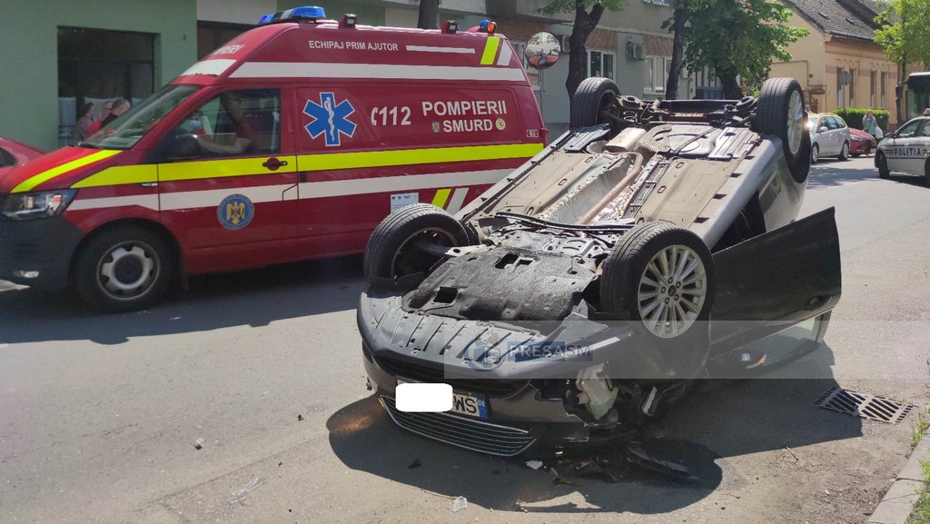 FOTO. Mașină răsturnată pe șosea, în Satu Mare. O șoferiță neatentă a provocat totul