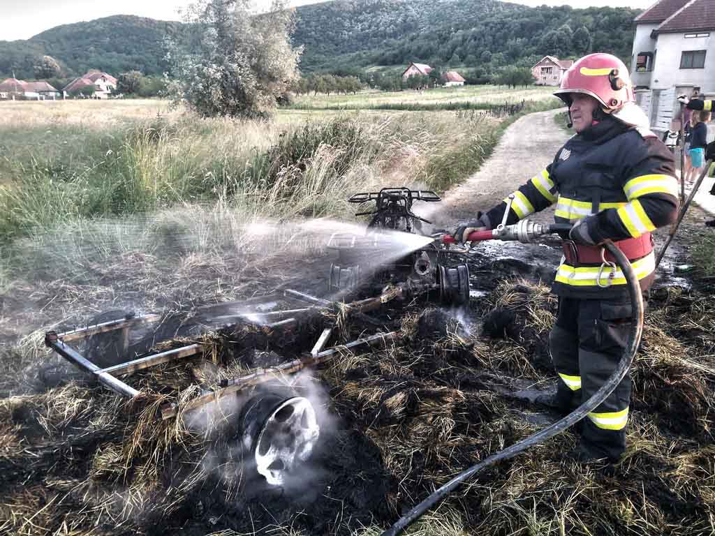 FOTO. Un ATV, care tracta o remorcă cu baloți de paie, a luat foc în mers