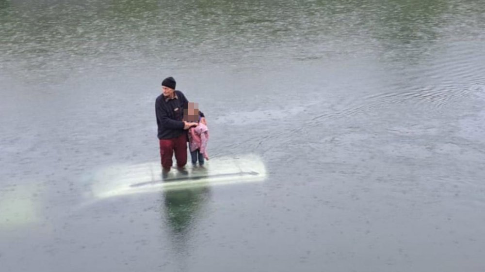 FOTO. Scenă desprinsă parcă din filme într-un județ din țară. Vârstnic şi o fetiţă, pe plafonul maşinii, în mijlocul apelor, aşteptând salvatorii