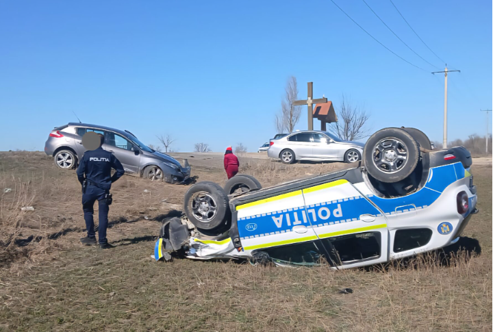 FOTO. Maşină de poliţie, răsturnată pe câmp, după un accident. Un elev a fost rănit