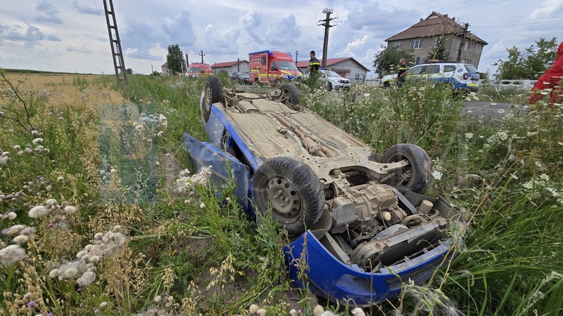 FOTO. Mașină răsturnată în șanț (2 victime) după ce a lovit un stâlp de electricitate, în județul Satu Mare